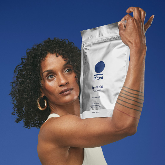 Photo of a woman holding a package of Ritual Essential Protein 